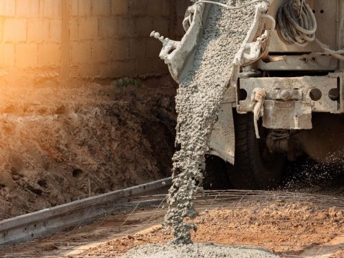 concrete being poured into a reinforced pole foundation at a construction site