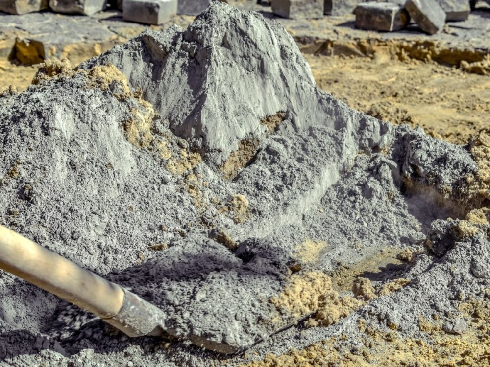 Cement and sand being mixed with a shovel for foundation works